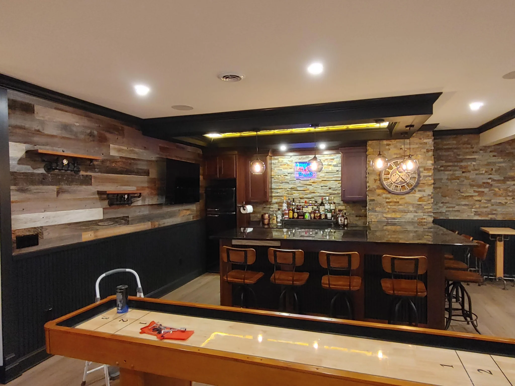 Finished basement media room with star ceiling, stacked stone wall and linear fireplace